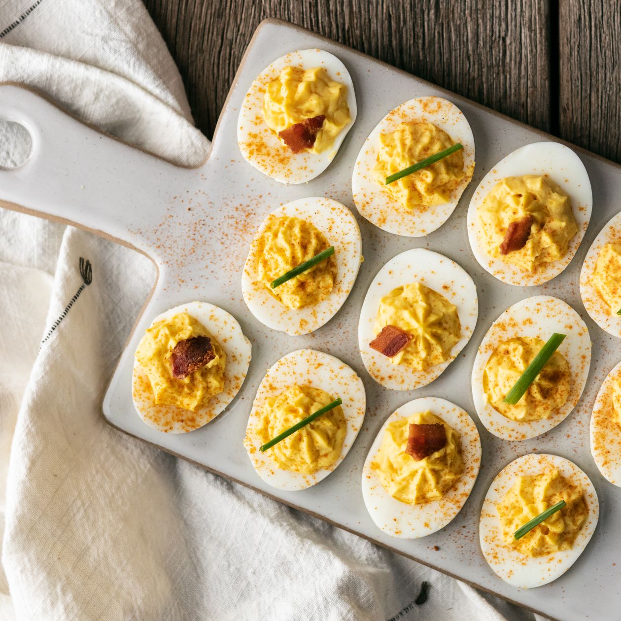 deviled eggs on white ceramic tray with dish towel