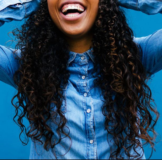 woman with long curly hair in chambray shirt