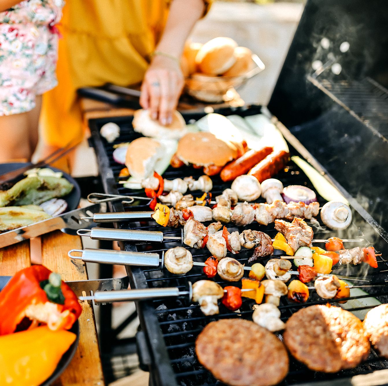 vegetable skeweres hot dogs burgers buns on grill