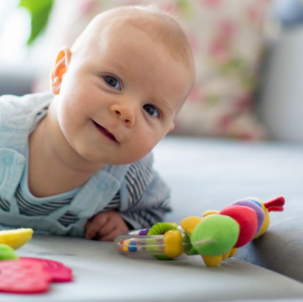 baby on tummy with rattles