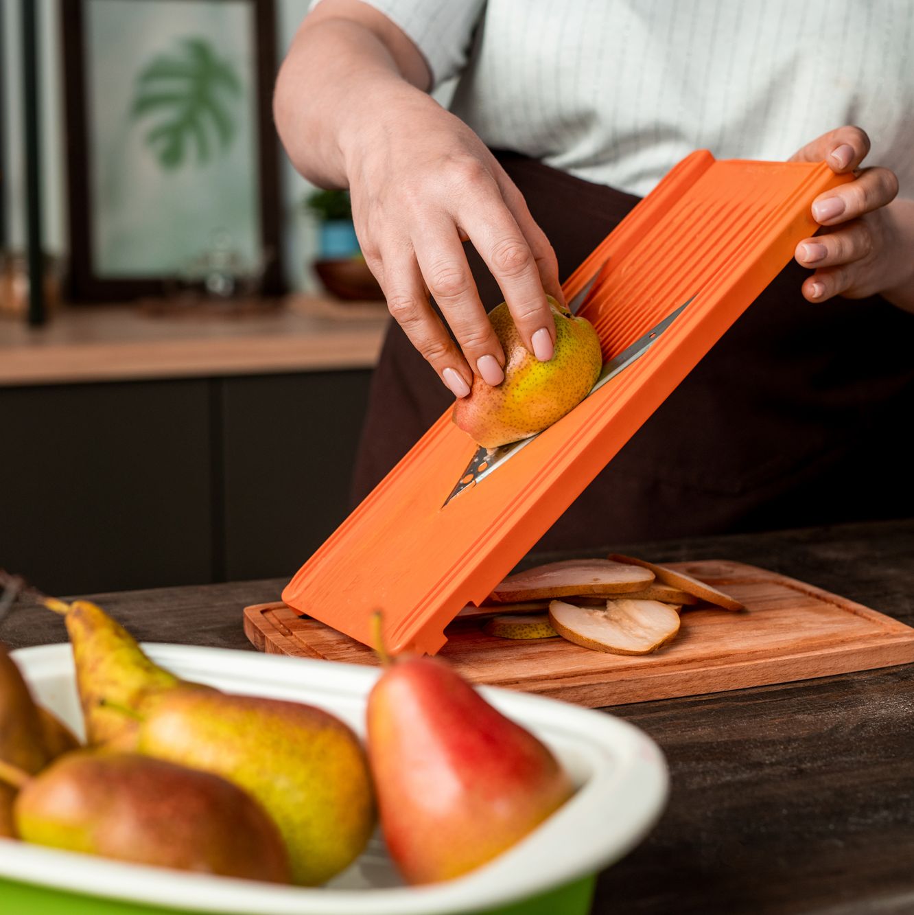 person slicing pears on mandoline slicer